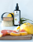 Yuzu Körperöl mit Massagebürste frische Zitrusfrucht Yuzu aufgeschnitten oelfaktorisch körperöle